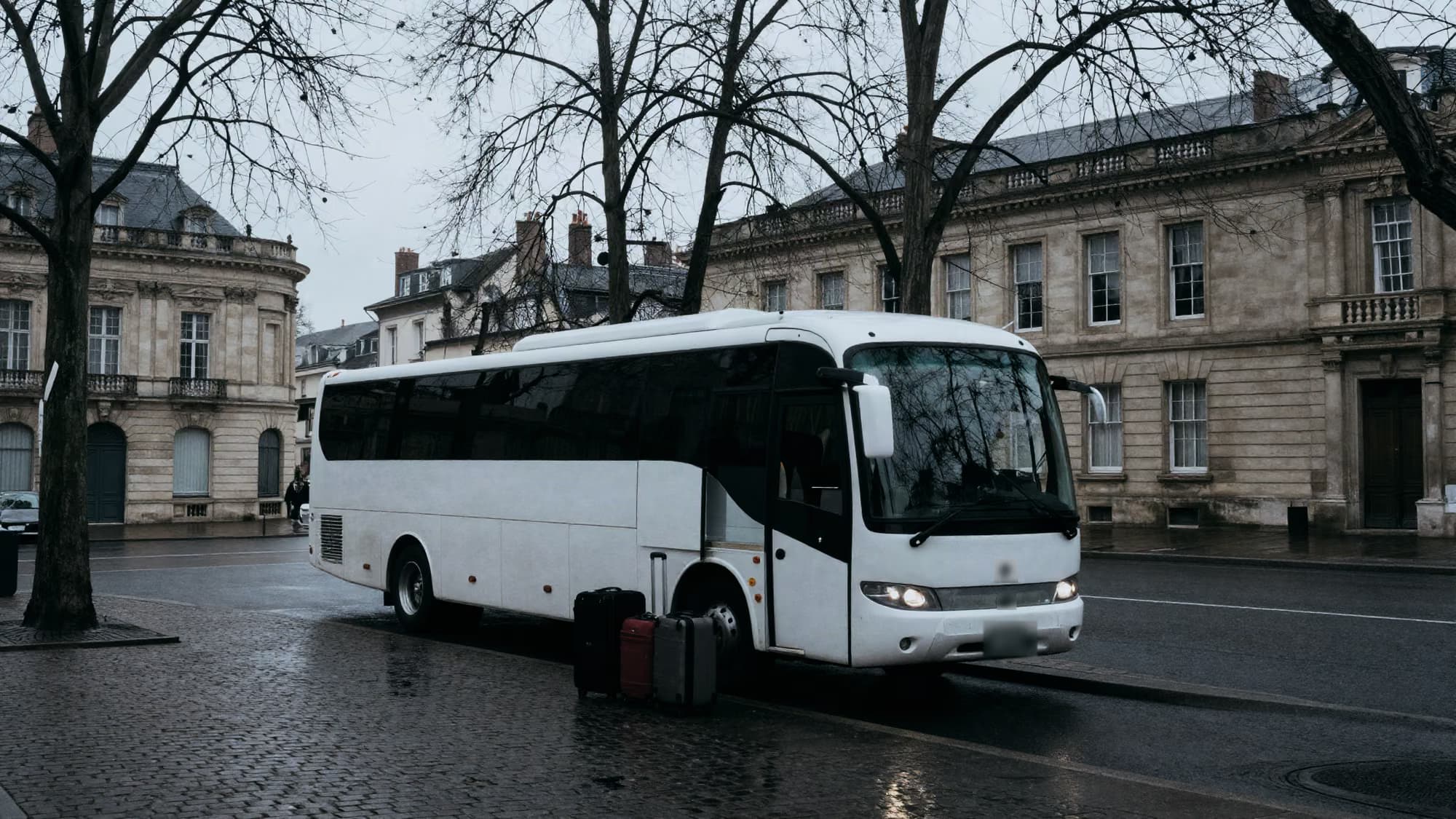 Autocar à l’arrêt, soute ouverte, valises alignées sur le trottoir.