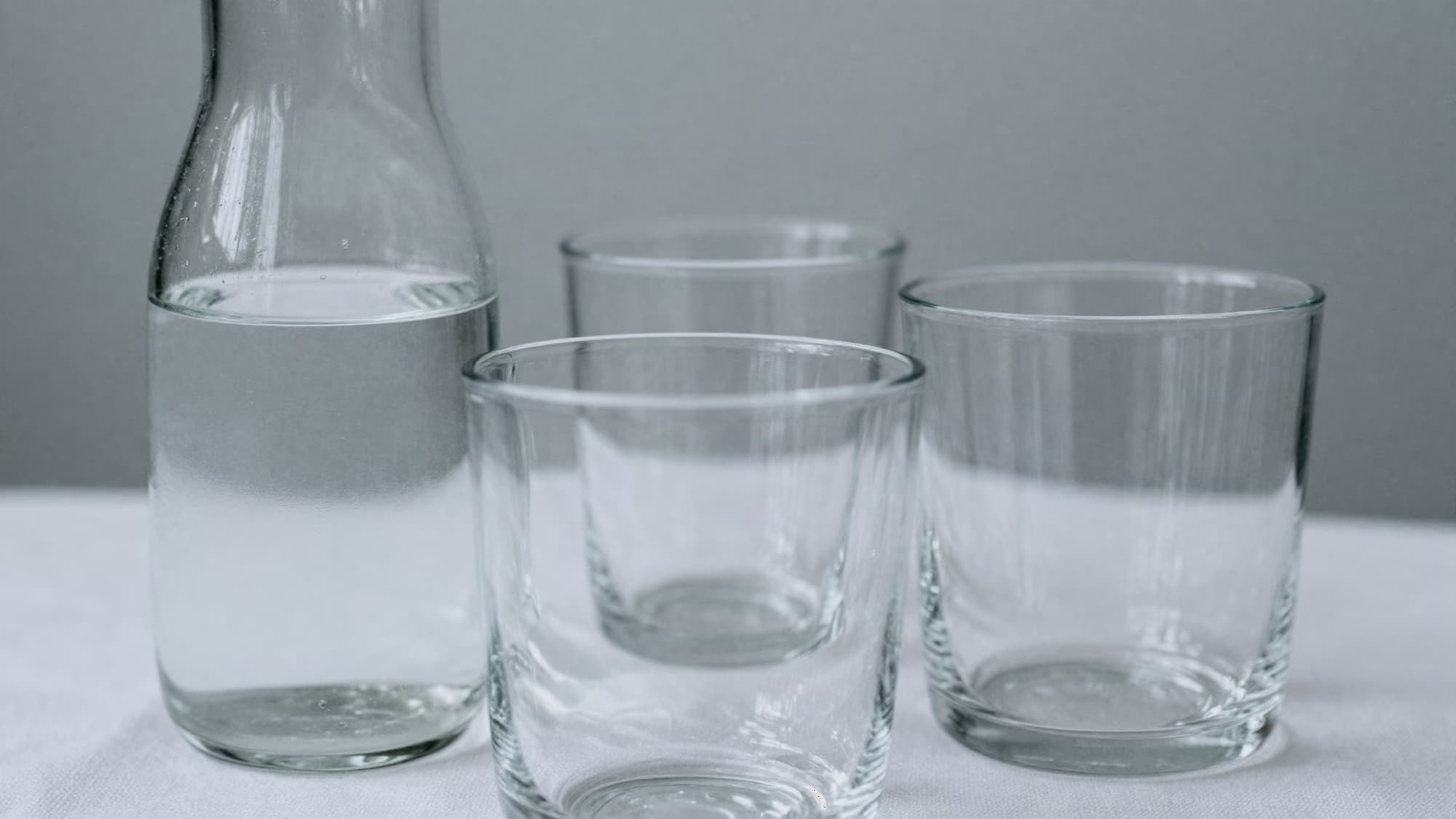Carafes et verres alignés sur une table d’accueil