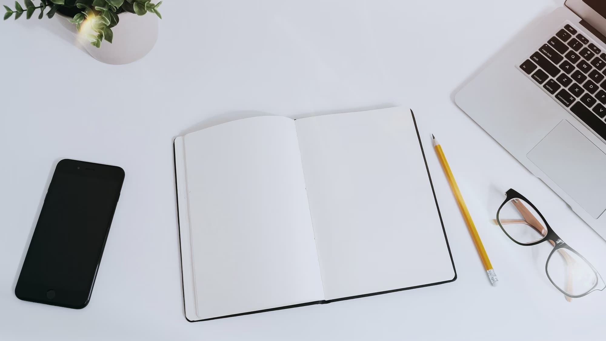Carnet ouvert, crayon et lunettes sur un bureau