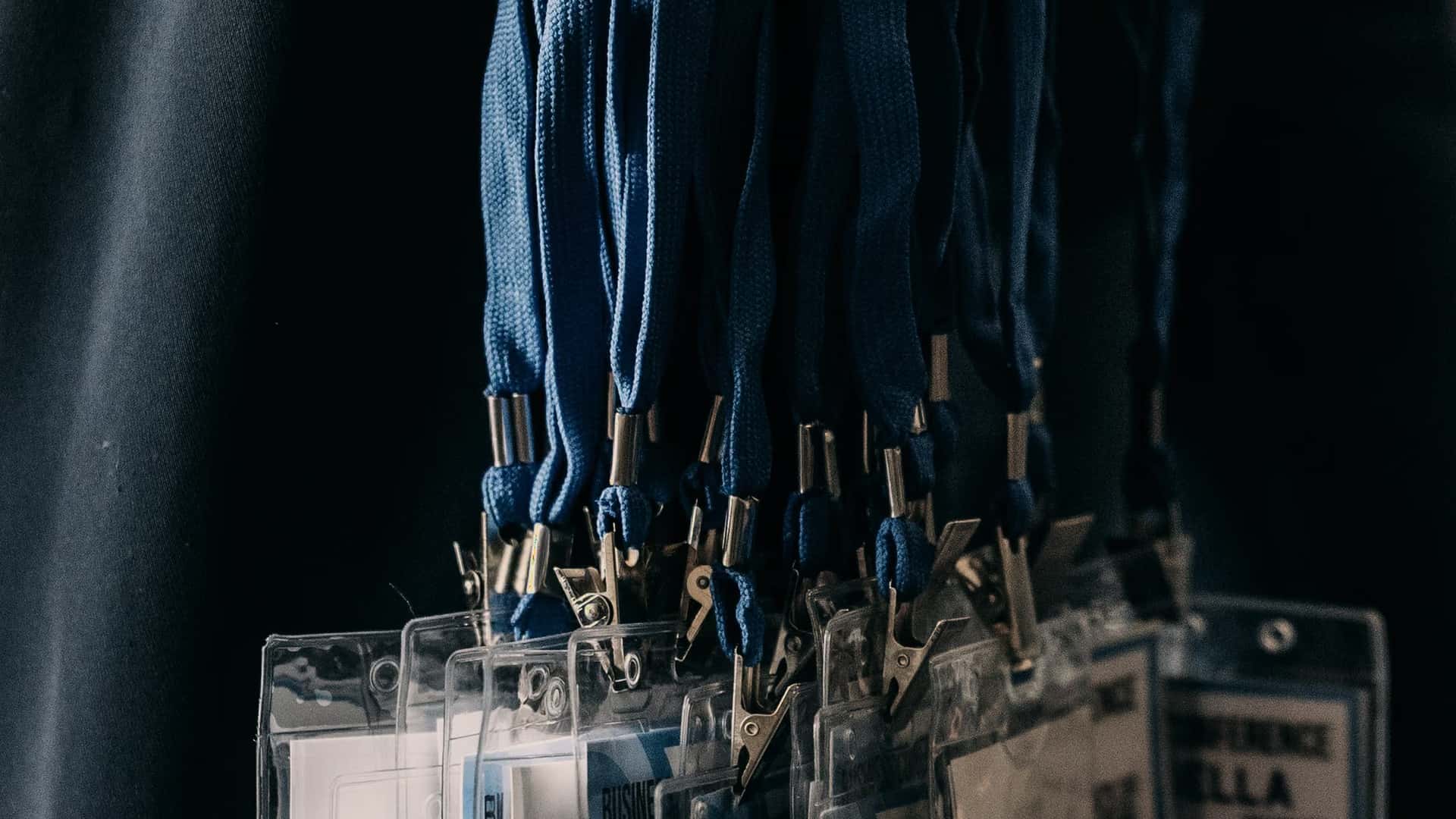 Cordons et porte-badges alignés sur une table d’accueil