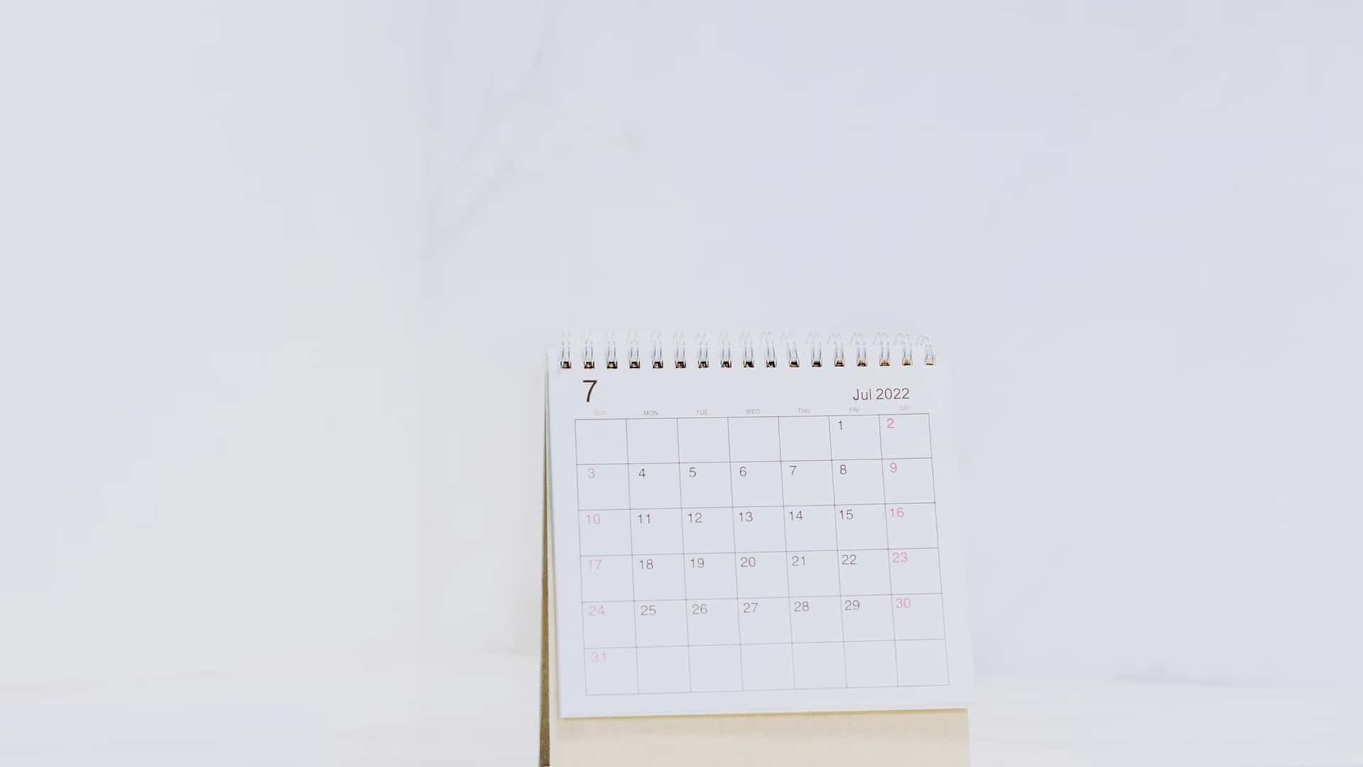 Petit calendrier de bureau à spirale, posé sur fond clair