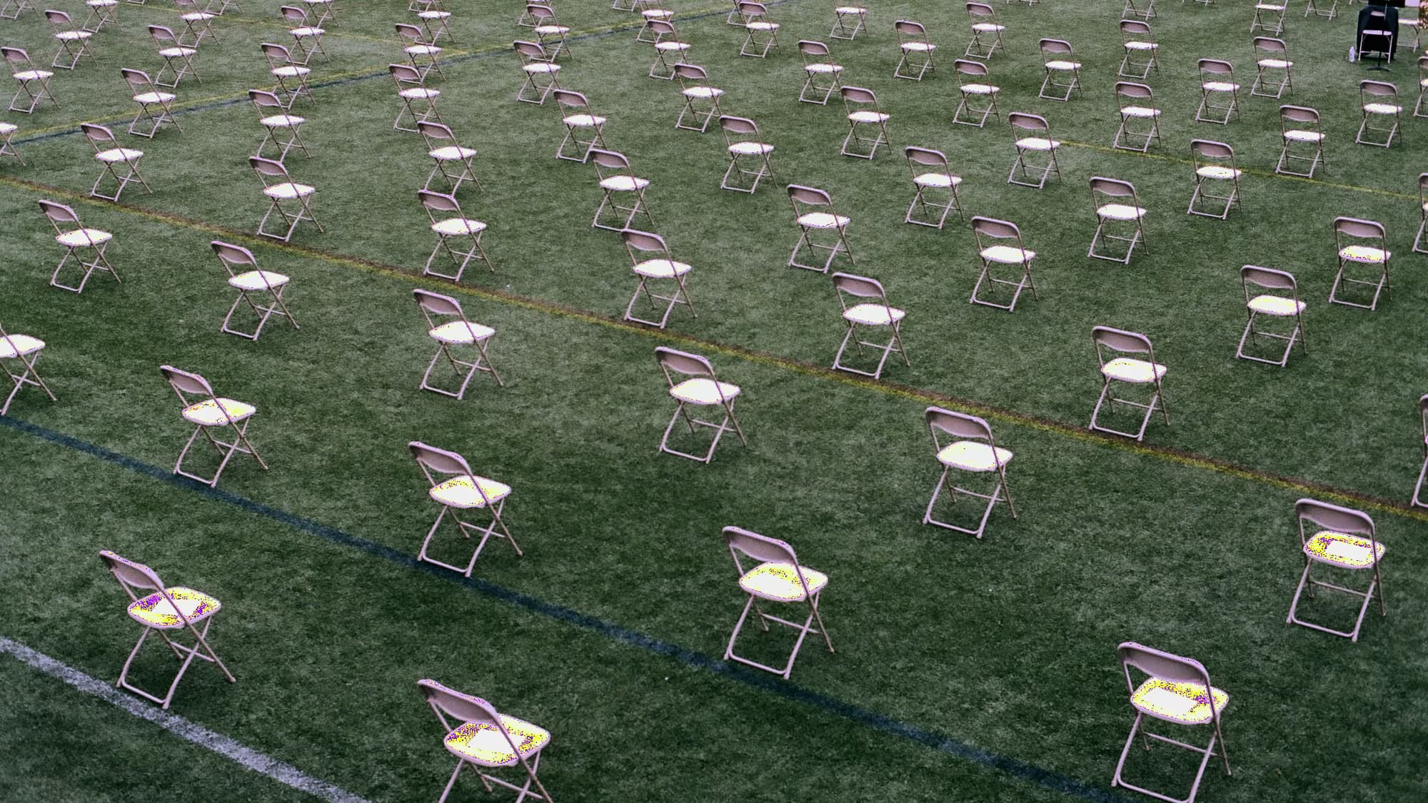 Chaises pliantes disposées sur une pelouse, avant l’arrivée du public