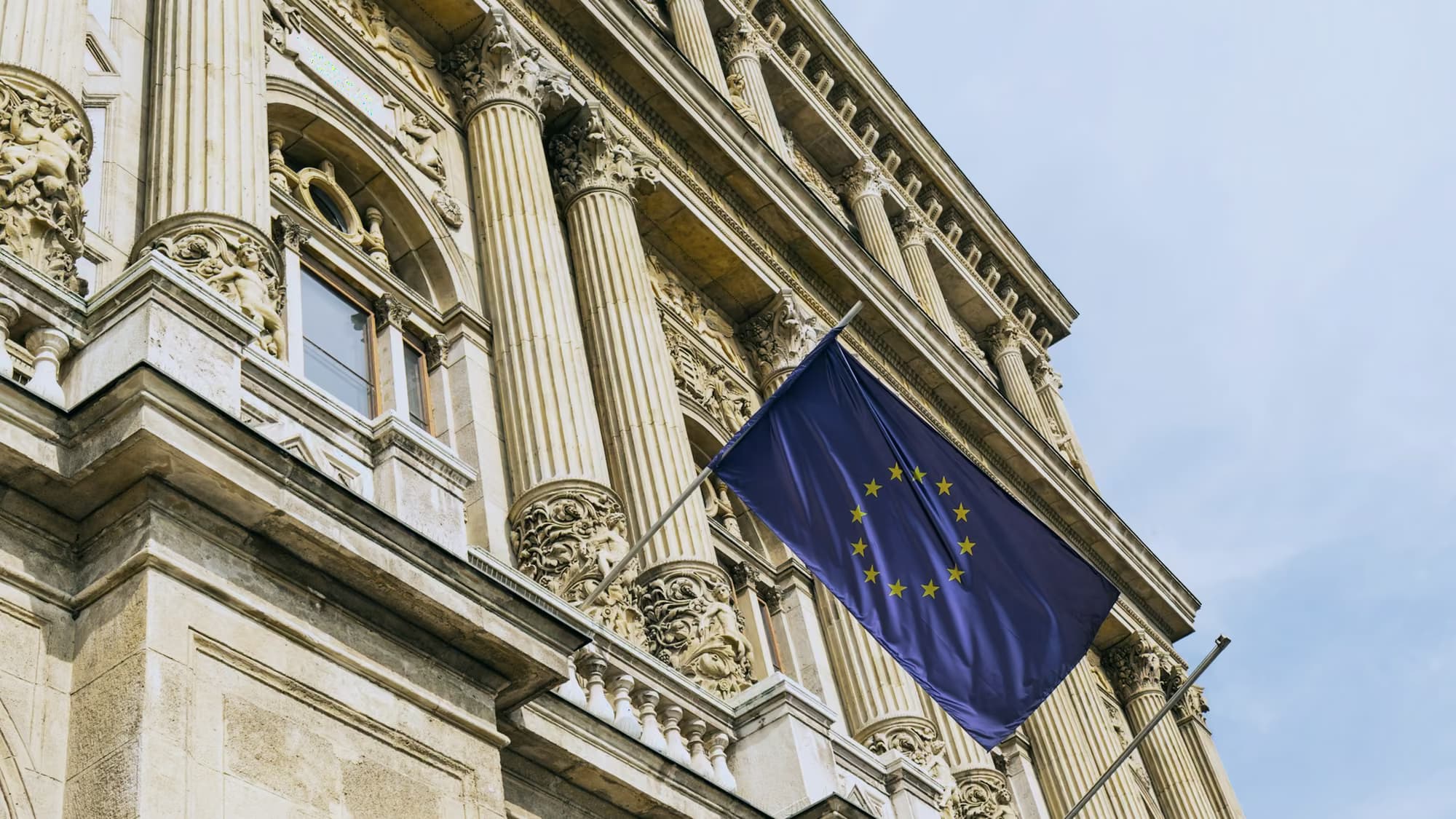 Drapeau européen déployé sur la façade de pierre d’un bâtiment public