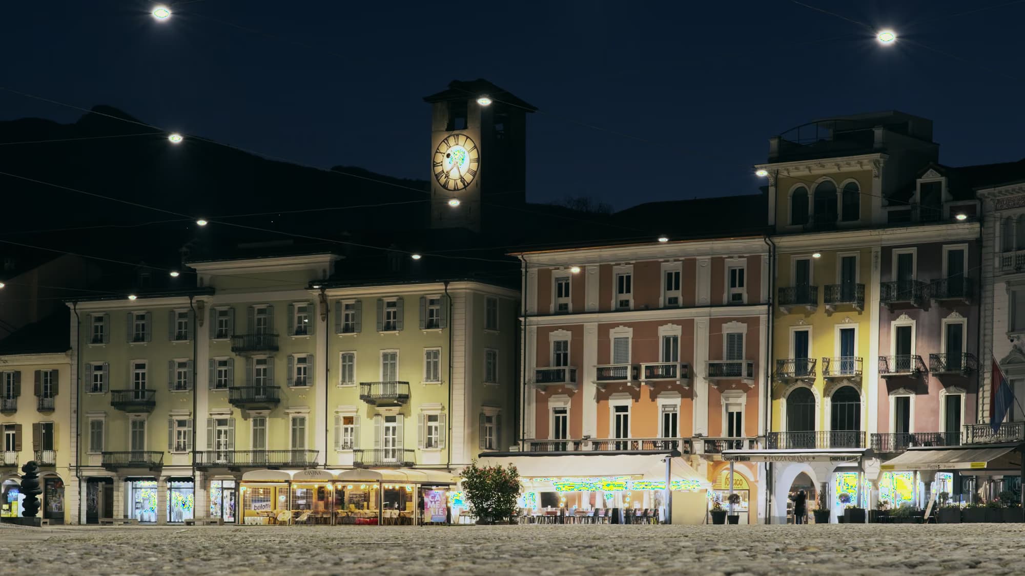 Place de ville au crépuscule, façades éclairées au-dessus du pavé